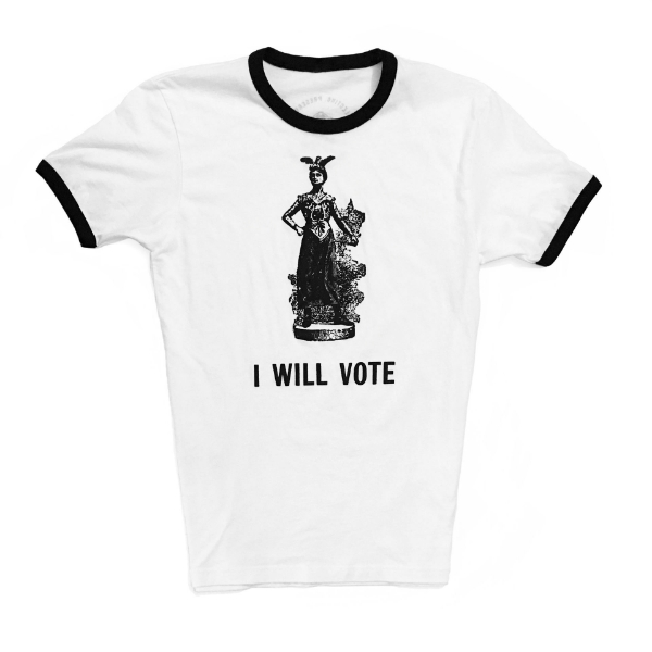 Frontside of the white crew cut t-shirt with black ribbing on the neck and sleeves. The black text "I Will Vote" is underneath a black and white engraving of a suffragist  in a Greek costume on a pedestal.