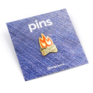 Irregular shaped pin of two crossed logs with orange and yellow campfire flames.