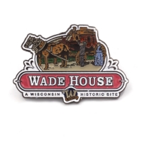 Lapel pin shaped as the Wade House historic site logo. The top half of the logo is a man driving a carriage driven by two horses talking to a man and women dressed in old-fashioned clothing. Under that image is the site name "Wade House" in a red banner, and "A Wisconsin Historic Site" underneath.