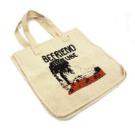 A tan colored tote bag with matching handles. The illustrated image on the tote shows a big black tree, brown colored grass with white and black mushrooms, outlines of mountains in the skyline, and dotted lines indicating clouds. The text is in black vintage bubble letters and reads "Befriend Nature".