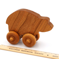 Handcrafted Wooden Bear Push Toy in Cherry next to ruler