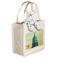 A stuffed animal pig is hanging out of an off-white colored tote bag with same colored handles and an illustrated image of the Wisconsin State Capitol set against a sky with orange-tinted clouds. A small Wisconsin Historical Society logo is in the bottom left corner of the image.