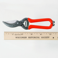 Pocket pruner next to a ruler measuring 5 1/2" long.