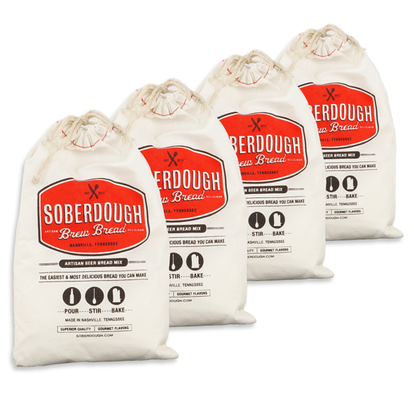 Four white canvas bags holding breadmix. Red lable says "Soberdough"