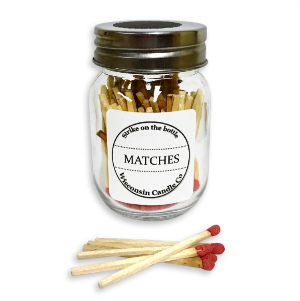 Small glass jar with tin screw cap top filled with matches. Five matches in foreground.