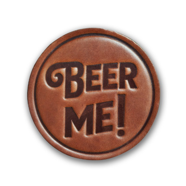 Round leather beverage coaster, medium brown, embossed with words that say "Beer Me!"