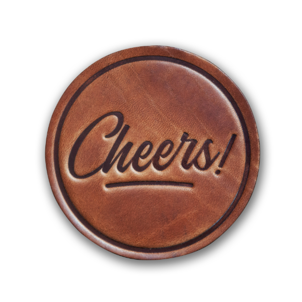 Round leather coaster, medium brown, that says "Cheers!" in cursive font.