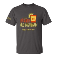 	Frontside of a dark gray crew-cut t-shirt with an orange and yellow design and font. A yellow lemon slice sits on the lip of an orange, short cocktail glass with a cherry shaped like Wisconsin. The print says "The Brandy Old Fashioned", underneath: "Sweet Sour or Press", underneath: "Muddle. Garnish. Enjoy."