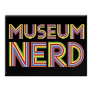 Rectangular refridgerator magnet, black, with text that reads "Museum Nerd" in large rainbow font.