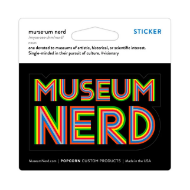 Museum Nerd sticker on display card. On the sticker, the word "Musuem" is above the word "Nerd." Pinstripe rainbow font on black background. 
