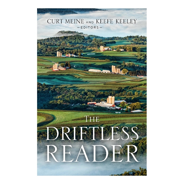 Book cover of "The Driftless Reader" with color photograph of several farms situated in rolling green hills of the driftless region. 