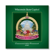 Square green box cover for the 2022 Commemorative State Capitol ornament. A full color picture of the ornament, with the farmers' market theme, is on the box cover. 