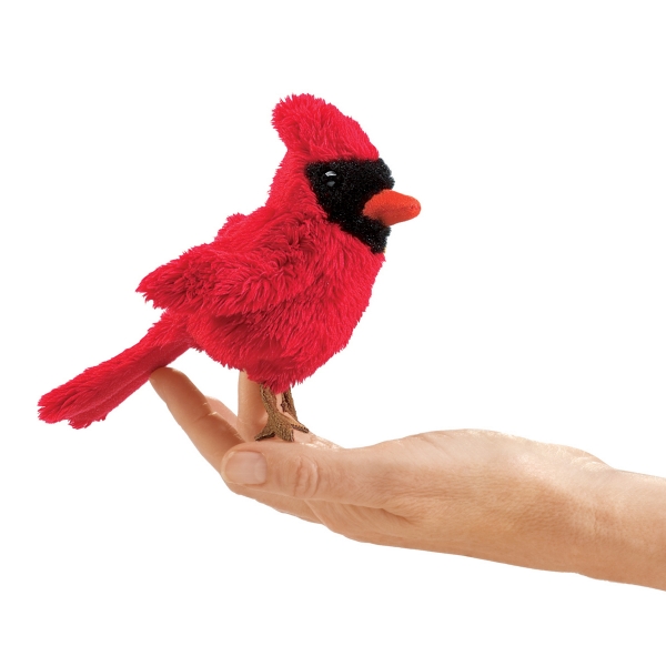 Human hand, palm up, holding a fuzzy-feathery cardinal finger puppet.