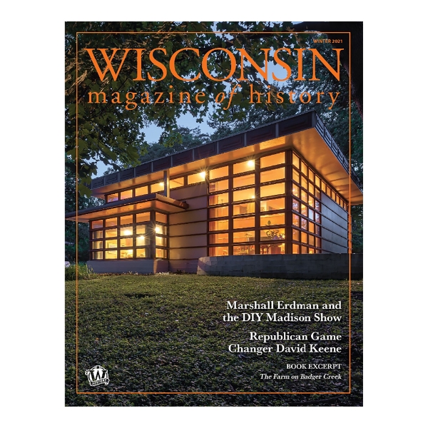 Cover of the Wisconsin Magazine of History Winter 2021 edition.A photo of the Walter and Mary Ellen Rudin house, built in Madison, WI, in 1957. One of three prefabricated homes designed by Frank Lloyd Wright and built by Marshall Erdman. Photographed at dusk from outside with the homes many windows illuminated from within.