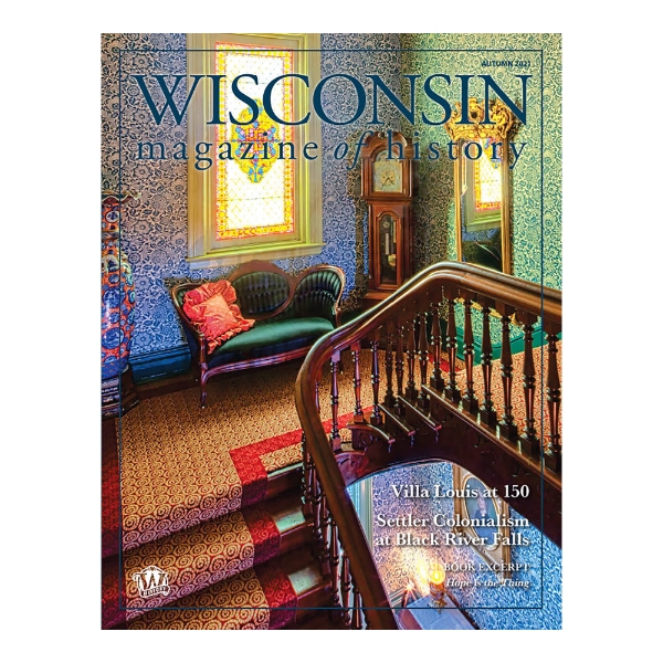 Cover of the autumn 2021 issue of the Wisconsin Magazine of History showing a full page photo of the Victorian interior of the Villa Louis Mantion in Prairie du Chien, Wisconsin. In the photo there is a stained glass window, blue floral wallpaper, a grandfather clock, and green loveseat with red pillow. 