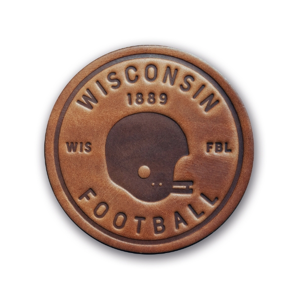 Round leather coaster, medium brown, with embossed helmet profile in the center and the words "Wisconsin Football 1889" embossed along the circumference. 
