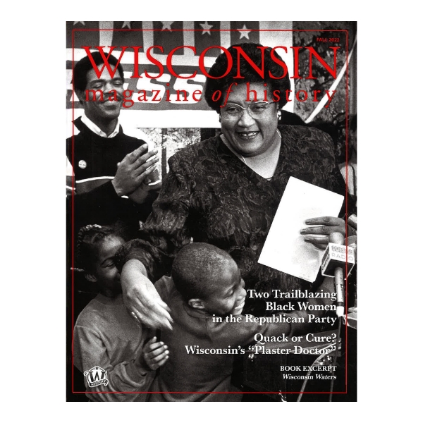Cover of fall 2022 issue of the Wisconsin Magazine of History with full page black and white photo of Helen Barnhill after 1988 election. A child is hugging her.