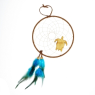 Dreamcatcher with tan leather frame, two blue feathers, and small wood turtle figure attached to webbing.