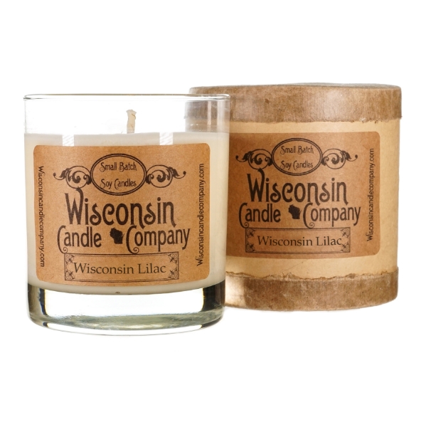 Candle in cylindrical clear glass container with kraft-paper label. Black font says Wisconsin Candle Company. 