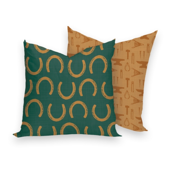 Square decorator pillow in green and gold with horseshoe design print on one side and blacksmith tool silhouettes on the other.