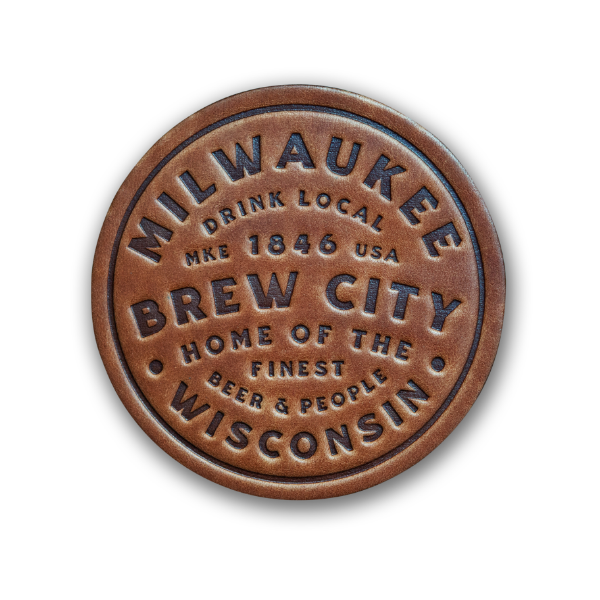 Round leather coaster, brown, with embossed, bold font that says Milwaukee Brew City Wisconsin. 1846.