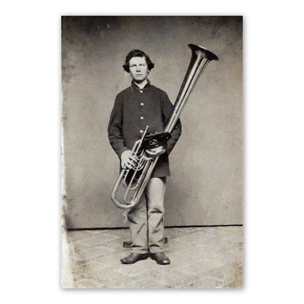 Black and white photo of civil war soldier holding large brass horn. Sepia tone.