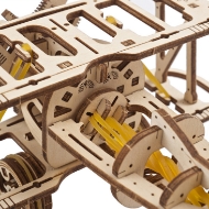 Close-up of small wooden model of a biplane, assembled, made of wooden parts that were laser cut from thin wood. View from above showing top wing and view of rubberband propeller.