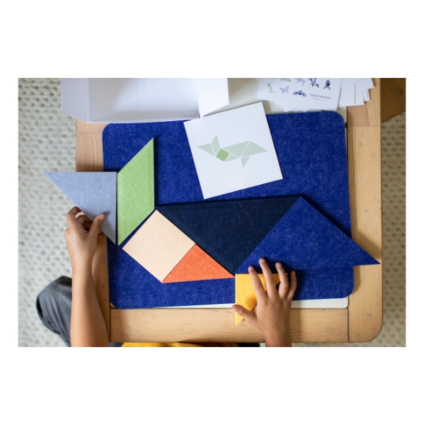Overhead view of child playing with geometrically cut felt blocks on felt play board.