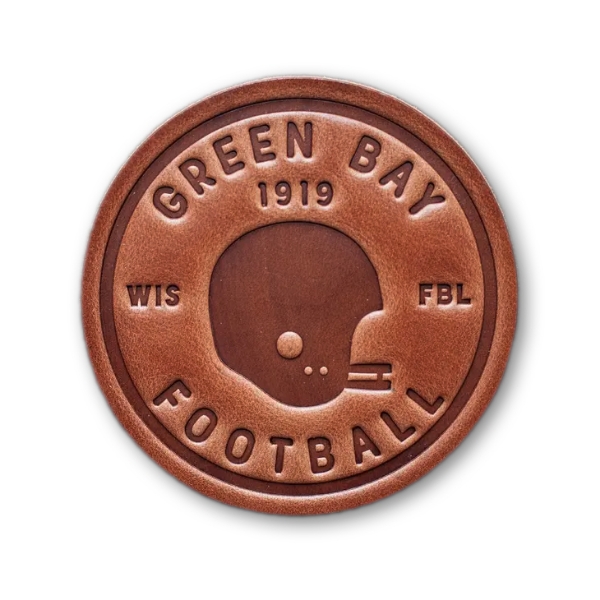 Circular, brown leather coaster with embossed football helmet and text that reads "Green Bay 1919 Football"