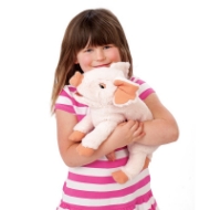 Smiling young girl in striped shirt hugging fuzzy pink piglet hand puppet with perky ears. 