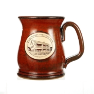 Red stoneware mug with oval patch that says "Wade House Historic Site" over a line drawing of the Wade House building.