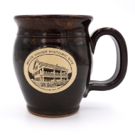 Brown stoneware mug with oval patch that says "Wade House Historic Site" over a line drawing of the Wade House building. Wide mouth and tapered base.