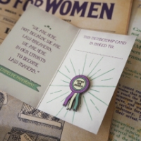 The "Votes for Women" Ribbon Enamel Pin in its packaging 