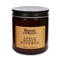 The Apple Maple Bourbon 16 oz candle in brown glass container, open, with black tin screw top leaning on side.