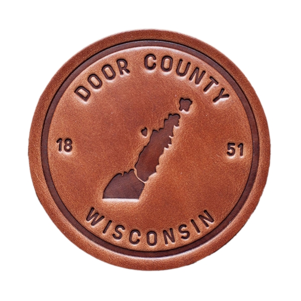 The front of the Door County Leather Coaster on a blank white background