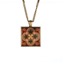 Square pendant with geometric leaf motif design. 