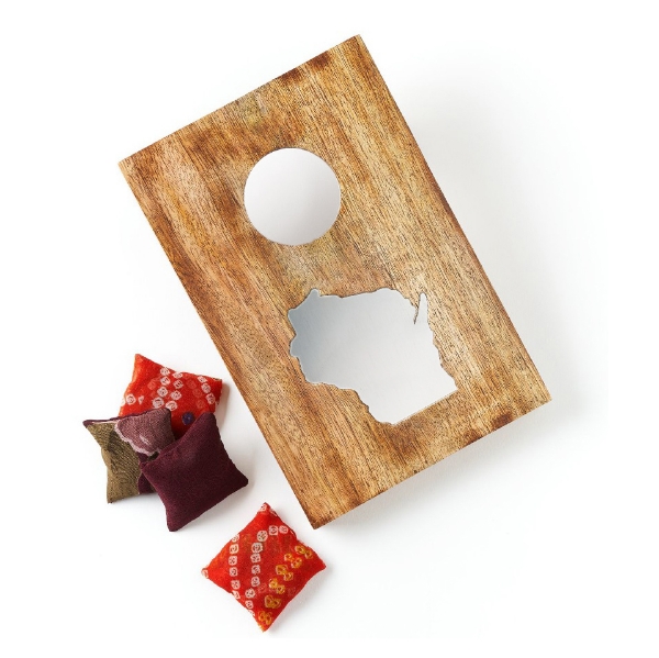 Wooden tabletop cornhole game with four small bean bags.