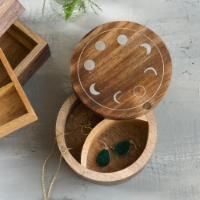 The brown wooden Moon Phase Round Jewelry Box open with jewelry inside, showing how the product should be used.