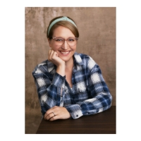 Portrait of author, Heather Kerrigan, wearing a plaid flannel shirt. 