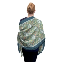 A back view of the William Morris Silk Blend Golden Lilies Shawl modeled on a woman.